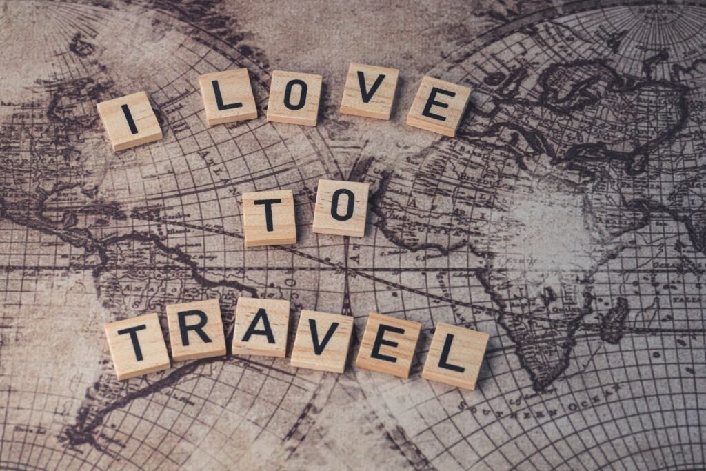 Wood scrabble tiles spelling 'I Love to Travel' on a vintage map.