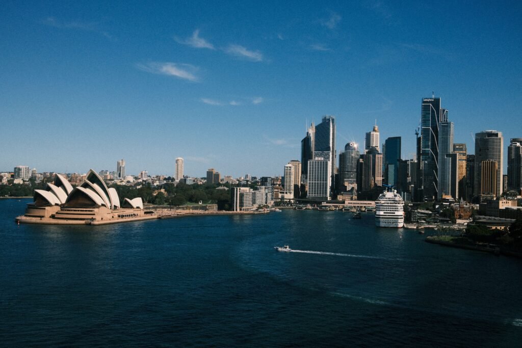 View of Sydney's skyline featuring the iconic Opera House and harbor during a sunny day.