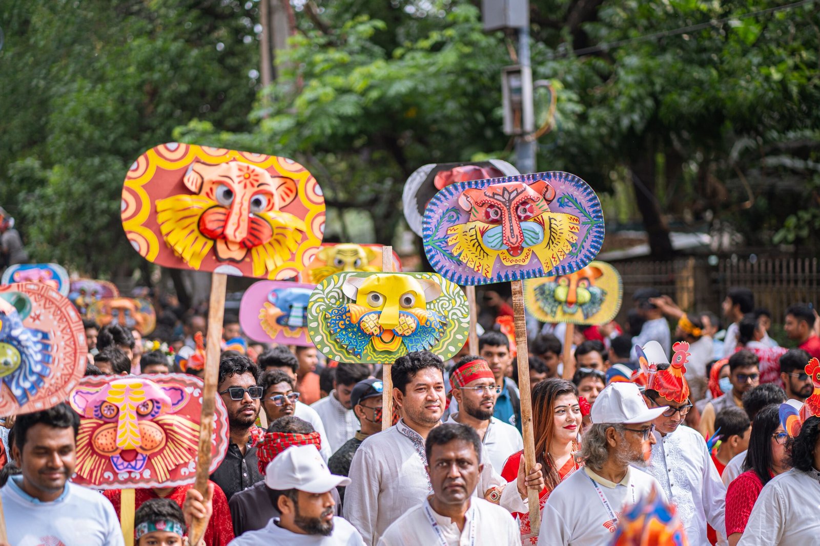 Colorful parade featuring traditional mask designs and large crowd at outdoor festival.